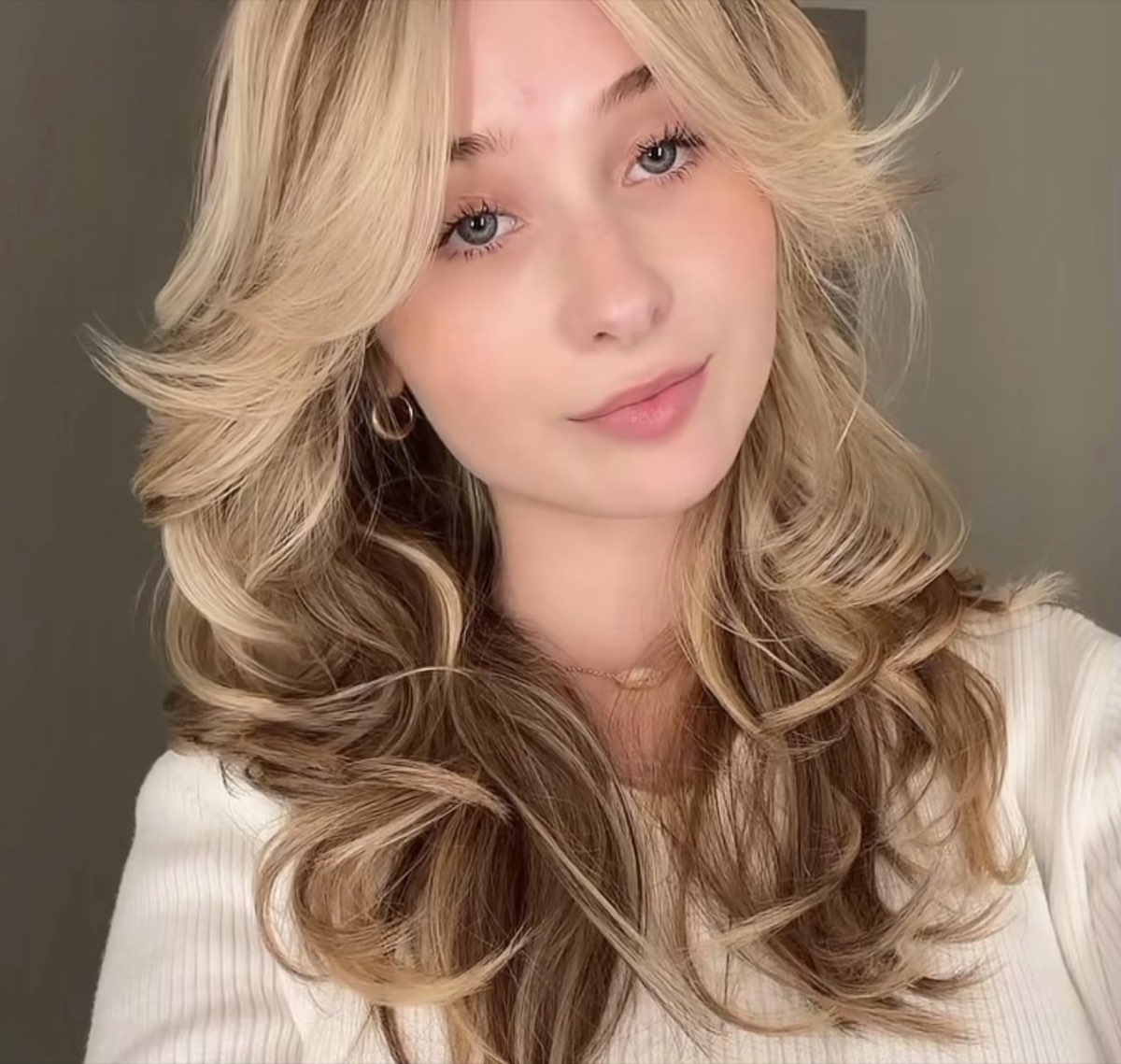 Layered cut with curtain bangs and a soft blonde blowout